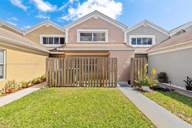 traditional home featuring a front yard, fence, and stucco siding