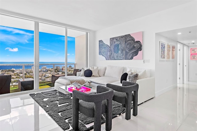 living area featuring a wall of windows, a water view, light tile patterned flooring, and baseboards