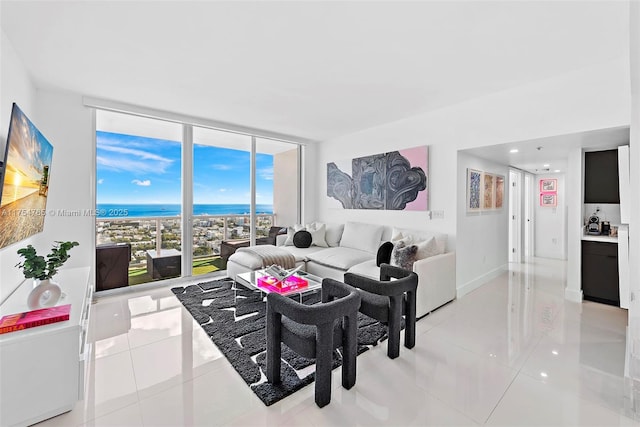 living area featuring expansive windows, light tile patterned floors, and baseboards