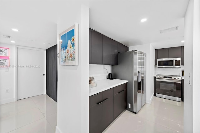 kitchen featuring appliances with stainless steel finishes, recessed lighting, light tile patterned floors, and modern cabinets