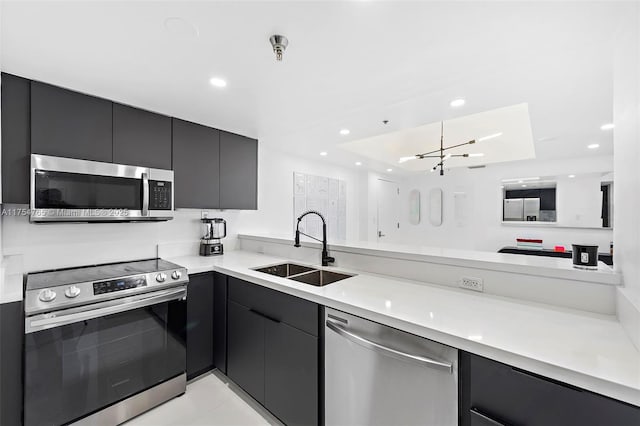 kitchen with modern cabinets, appliances with stainless steel finishes, light countertops, a sink, and recessed lighting