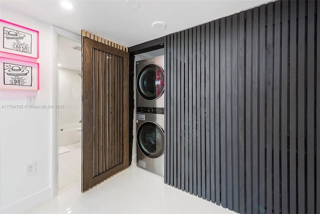 laundry area with laundry area, stacked washer / dryer, and tile patterned floors