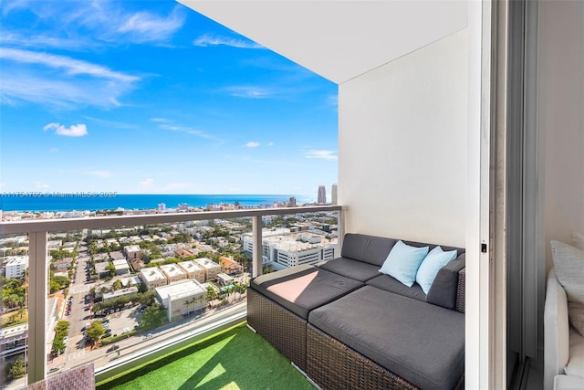 balcony featuring a water view and a city view