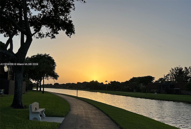 surrounding community with a yard and a water view