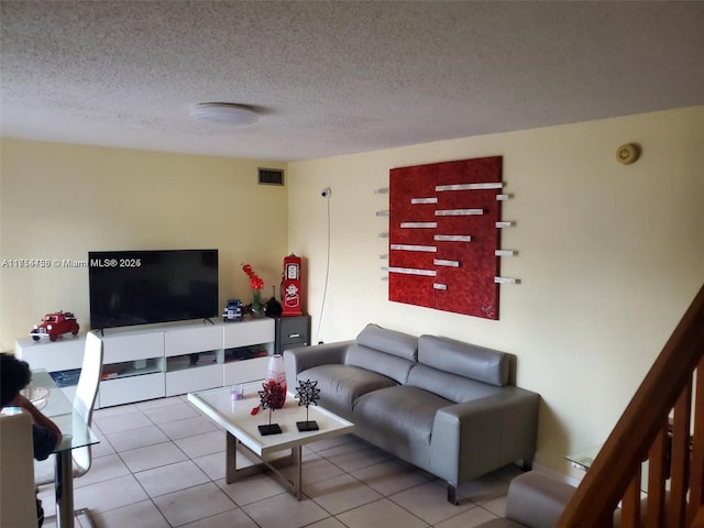 tiled living area featuring visible vents and a textured ceiling