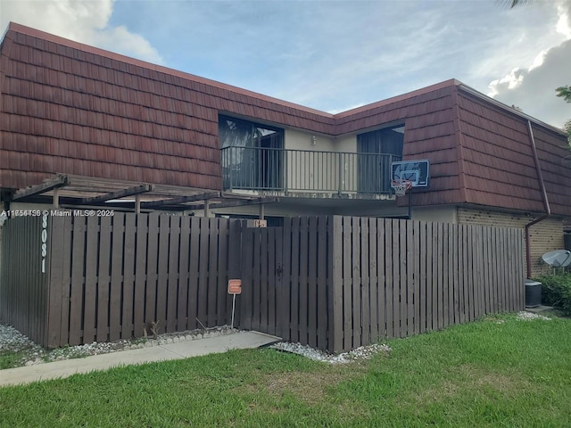 view of gate featuring a lawn and fence