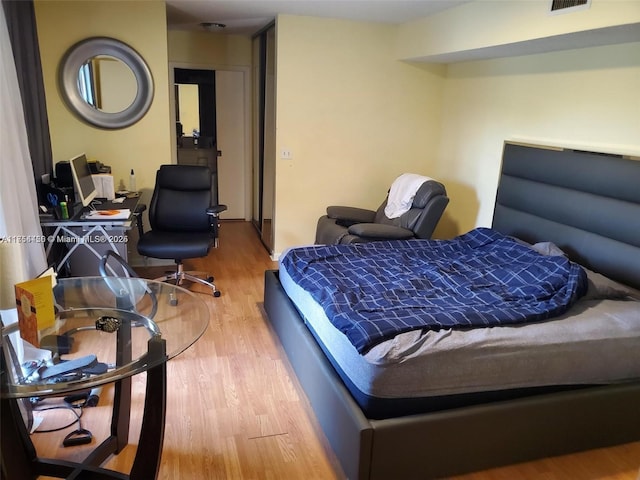 bedroom featuring visible vents and wood finished floors