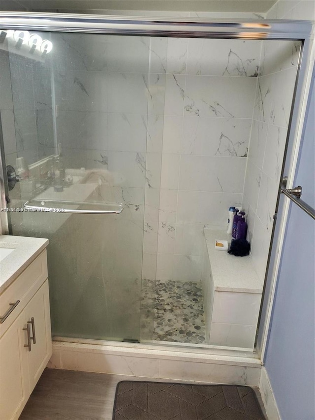 full bathroom featuring vanity, wood finished floors, and a shower stall