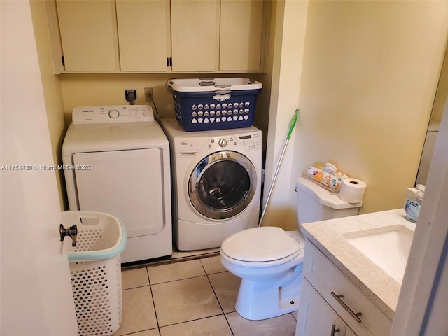 laundry room with washing machine and clothes dryer, laundry area, light tile patterned floors, and a sink