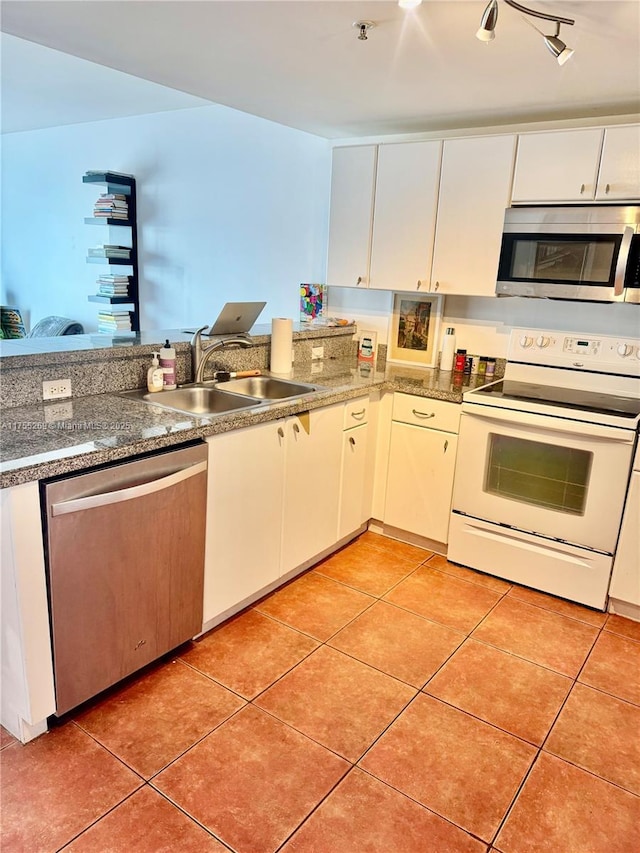 kitchen featuring stainless steel appliances, white cabinets, light tile patterned flooring, and a sink