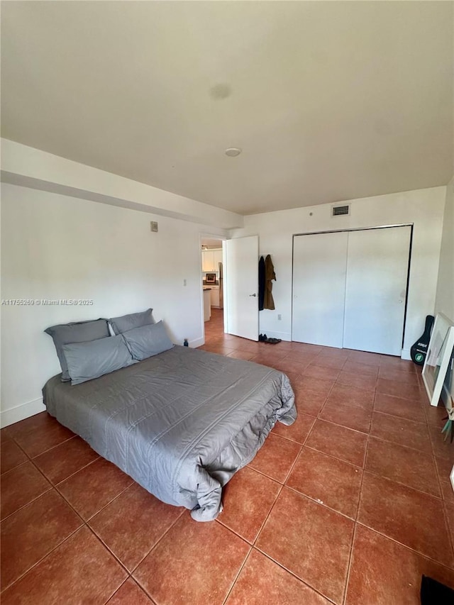 bedroom with tile patterned flooring, a closet, and visible vents