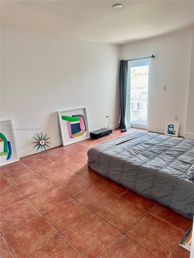 tiled bedroom featuring access to outside and baseboards