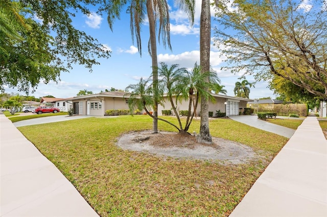 single story home featuring driveway, a front lawn, and an attached garage