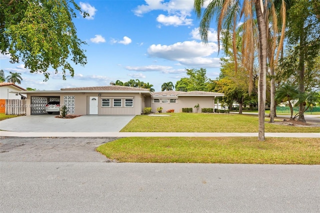 ranch-style house featuring driveway, a front lawn, an attached garage, and stucco siding