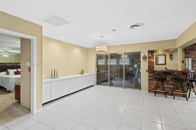 tiled dining area featuring visible vents, a chandelier, and a textured ceiling