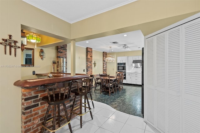 tiled dining room featuring visible vents, ceiling fan, crown molding, a bar, and recessed lighting