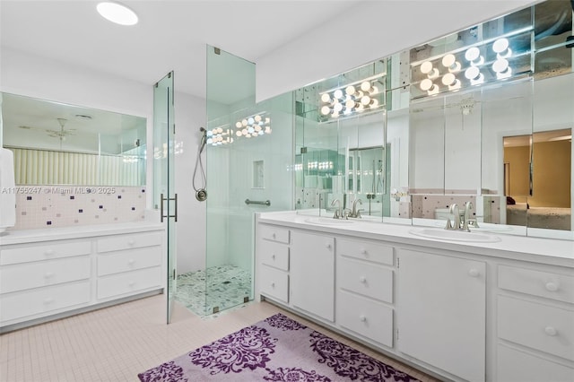 full bathroom with double vanity, a stall shower, a sink, and tile patterned floors