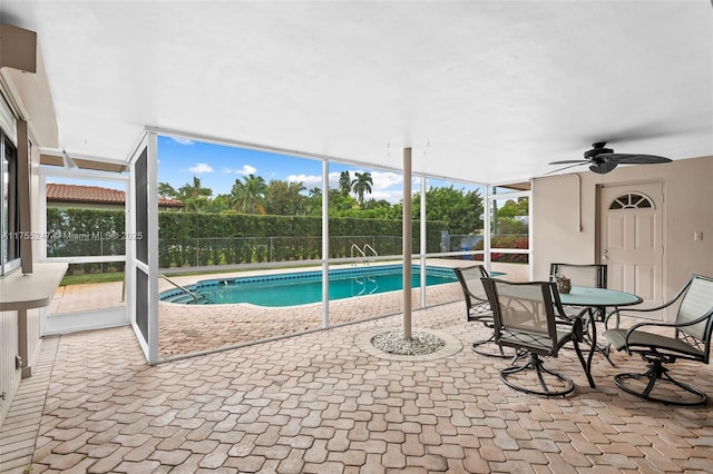 view of swimming pool with a fenced in pool, a patio area, glass enclosure, ceiling fan, and fence