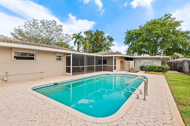 view of swimming pool featuring a sunroom, fence, a fenced in pool, and a patio