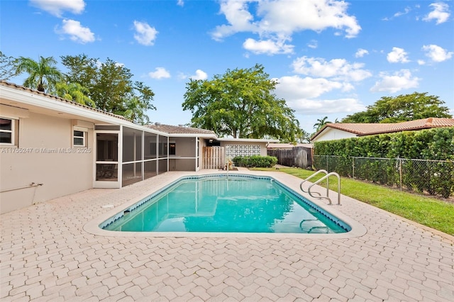 view of swimming pool featuring a sunroom, a fenced backyard, a patio area, and a fenced in pool