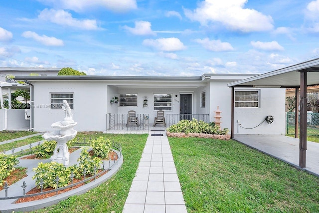 ranch-style home featuring covered porch, a front lawn, fence, and stucco siding