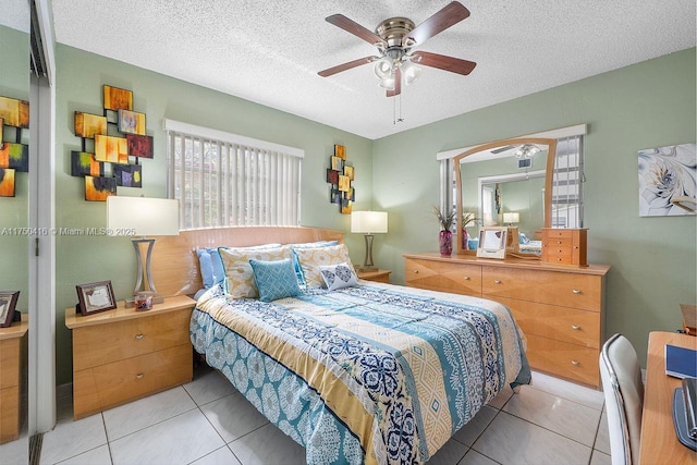 bedroom featuring a ceiling fan, a textured ceiling, and tile patterned floors