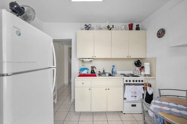 kitchen featuring white appliances, light countertops, a sink, and light tile patterned flooring