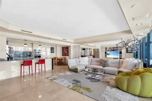 living room featuring visible vents, a raised ceiling, and ornamental molding