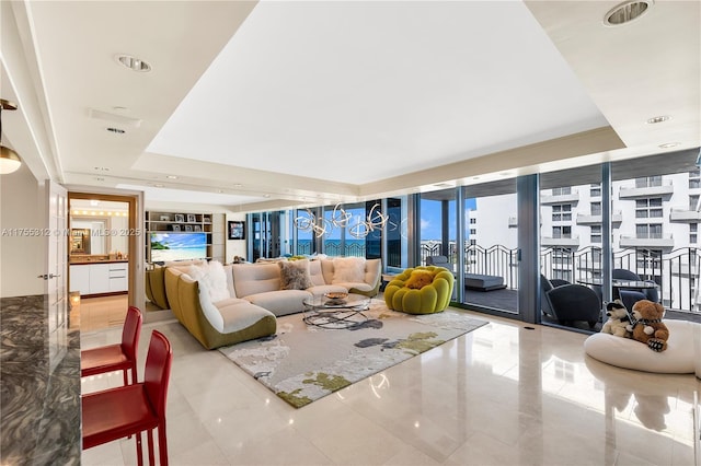 living room featuring a wall of windows, a tray ceiling, and recessed lighting