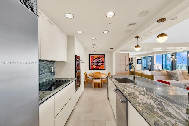 kitchen with visible vents, white cabinets, dishwasher, black electric stovetop, and a sink