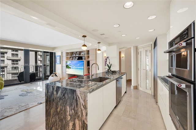 kitchen with stainless steel appliances, a sink, white cabinetry, french doors, and modern cabinets