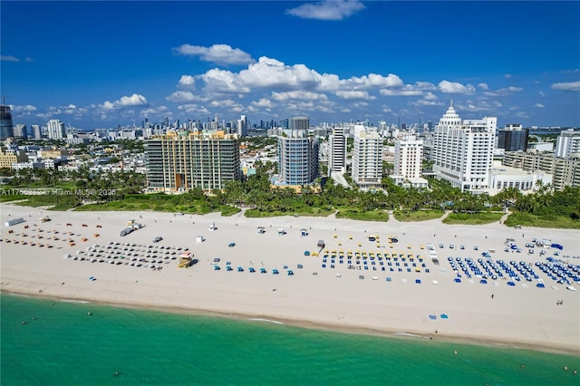 aerial view featuring a view of the beach, a water view, and a view of city