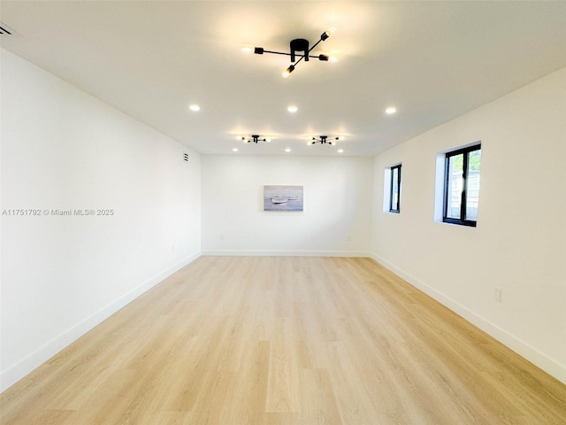 empty room featuring light wood-style floors, baseboards, and recessed lighting