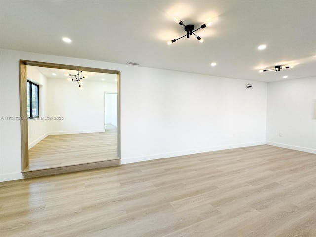 unfurnished room with light wood-type flooring, visible vents, baseboards, and recessed lighting