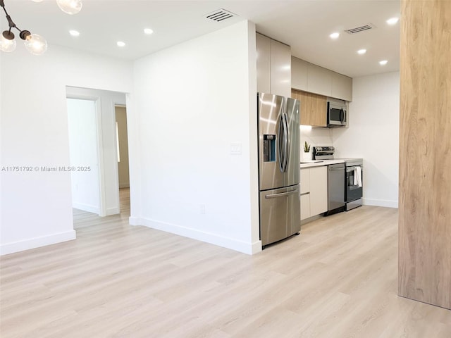 kitchen with stainless steel appliances, light wood-type flooring, visible vents, and modern cabinets
