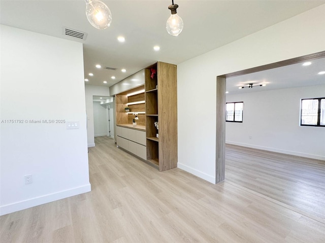 unfurnished room with recessed lighting, baseboards, visible vents, and light wood finished floors