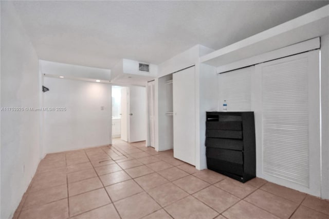 empty room featuring light tile patterned flooring and visible vents