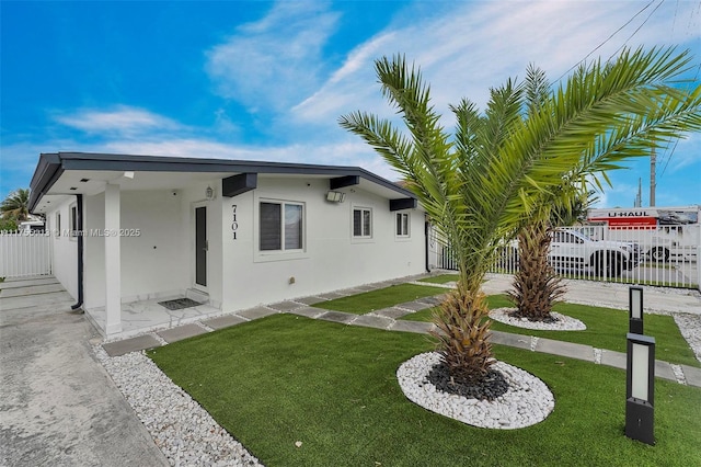 exterior space featuring a front yard, fence, and stucco siding