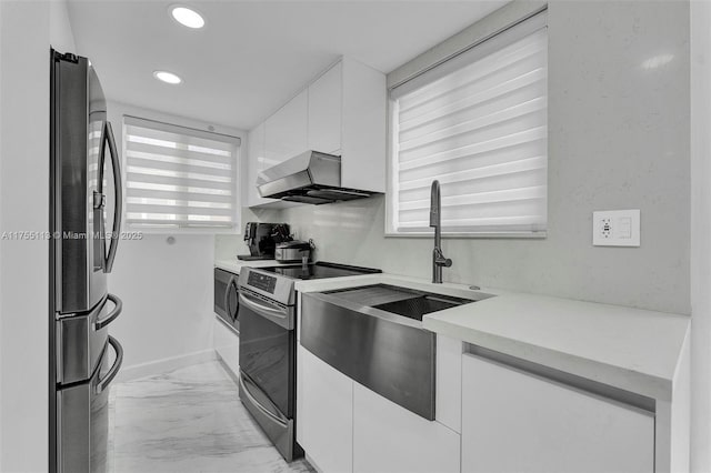 kitchen featuring range hood, marble finish floor, light countertops, appliances with stainless steel finishes, and white cabinets