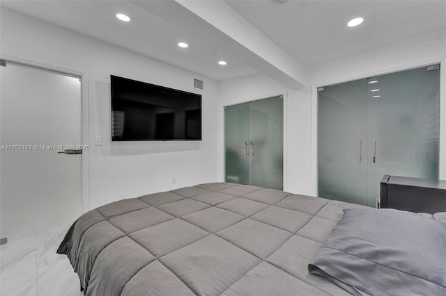 bedroom with a closet, recessed lighting, marble finish floor, and visible vents