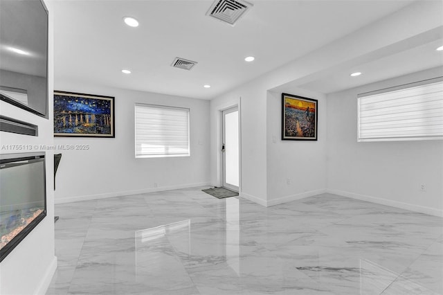 empty room featuring plenty of natural light, visible vents, and recessed lighting