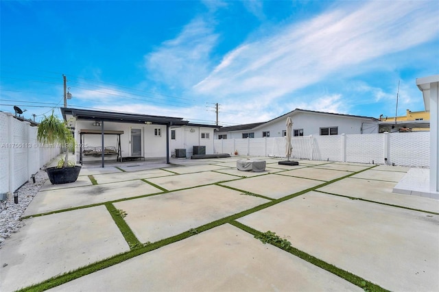 back of property featuring a patio area, a fenced backyard, a gate, and cooling unit