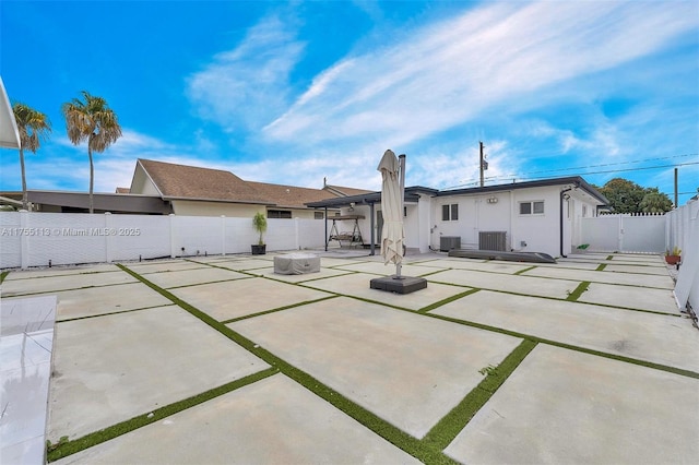 rear view of property with a patio area, a fenced backyard, a gate, and cooling unit