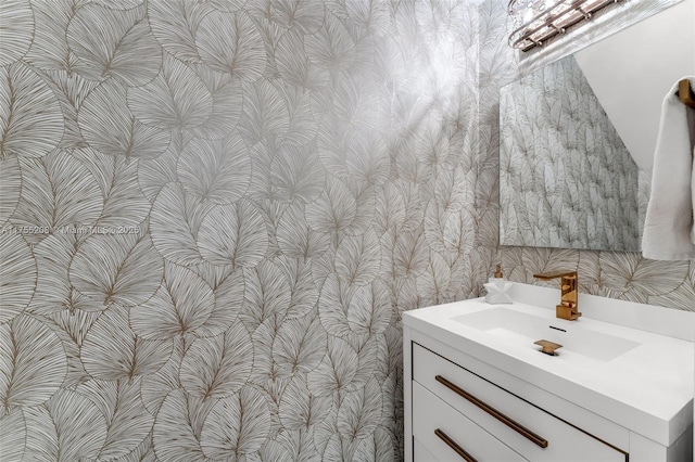 bathroom featuring vanity and wallpapered walls