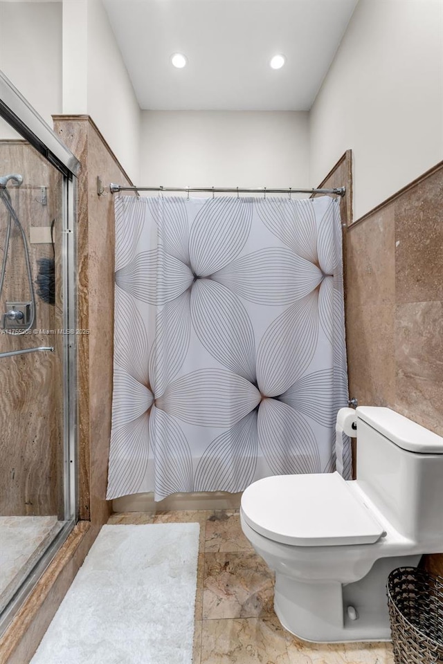 full bath featuring a shower stall and toilet