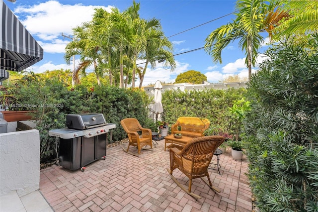 view of patio featuring a grill and fence