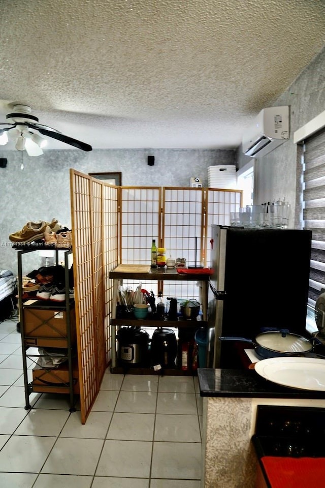 interior space featuring light tile patterned floors, a textured ceiling, and a wall mounted air conditioner