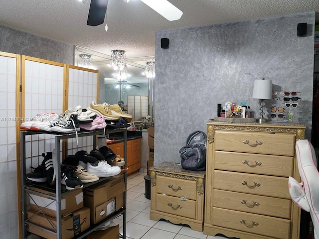 misc room featuring wallpapered walls, ceiling fan, a textured ceiling, and light tile patterned floors