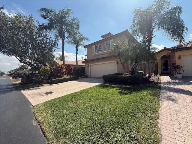 view of front of property featuring a garage, a front yard, driveway, and stucco siding