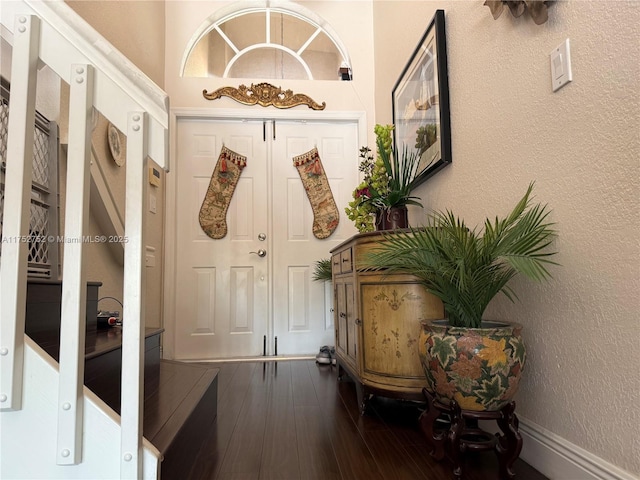 entryway with a textured wall and hardwood / wood-style flooring